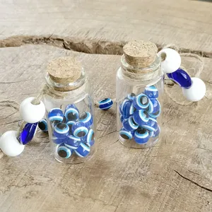 Two glass bottles filled with Turkish evil eye beads and rustic jute cord decor