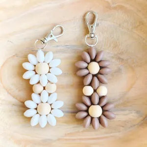 Bohemian floral keychains with wood beads and colorful petals on a wooden tray