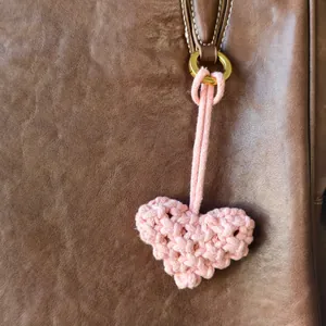 Pendentif cœur en crochet rose fait main avec anneau doré sur sac en cuir