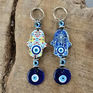 Detailed view of Hamsa Hand and Blue Evil Eye keychains with ethnic floral patterns