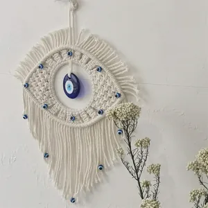 Close-up of handmade macrame evil eye wall hanging with blue glass beads and fringes