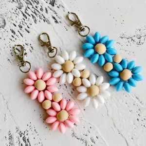 Detail showing colorful silicone flower keychains with wooden beads and silver metal hooks