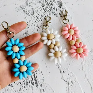 Macro detail of colorful daisy keychains with wooden centers and silver metal clips