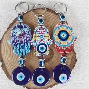 Three-piece Evil Eye and Hamsa Hand charms displayed on a wooden base for home decor