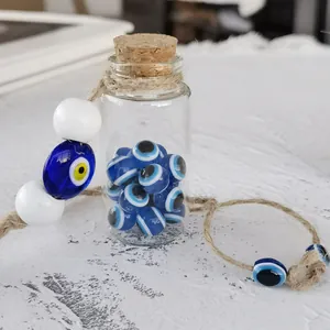 Detail of Turkish evil eye glass bottle with cork stopper and twine on rustic wood