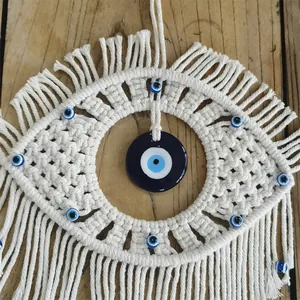 Macro detail of handmade macrame evil eye wall hanging with blue glass beads
