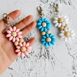Detail of colorful flower keychains with silicone petals and natural wood beads