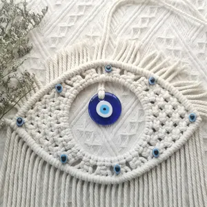 Detailed macro view of handmade macrame Evil Eye wall hanging with blue beads and tassels