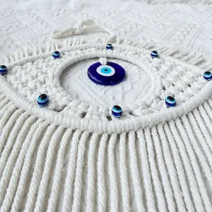 Detailed close-up of handmade macramé Evil Eye wall hanging with blue glass beads