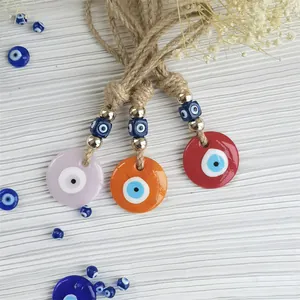 Macro detail of three colorful evil eye charms with gold beads and woven ropes