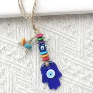 Hamsa hand wall hanging with blue evil eye charm and colorful wooden beads on rope