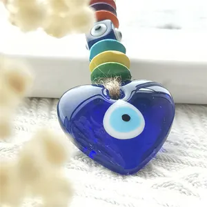 Macro shot of colorful wooden beads and blue evil eye heart pendant with hemp rope details