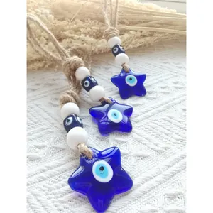 Dettaglio di tre ciondoli a stella malocchio con corda di canapa e perline blu
