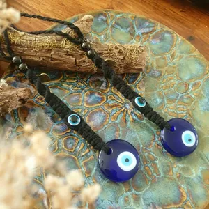 Détail d'amulette Mauvais Oeil faite main avec verre bleu et corde tressée en décor