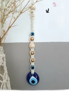 Detailed macro shot of handmade Macrame Evil Eye wall hanging with blue glass bead