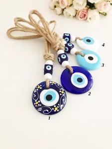 Dettaglio di quattro ciondoli Evil Eye in vetro con corda di canapa e perline per decorazione