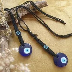 Vue détaillée de pendentifs mauvais œil avec perles en verre poli sur une branche en bois