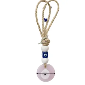 Handgemaakte wanddecoratie met boze oog kralen en een roze hars hanger