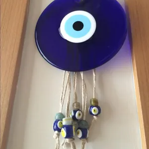 Dettaglio di occhio turco in vetro da parete con corda di iuta e perline blu