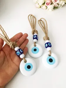 Dettaglio ravvicinato di tre amuleti Malocchio con corda di canapa e perle di vetro blu