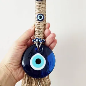 Close-up of Turkish Evil Eye glass pendant with rustic jute rope and decorative blue beads