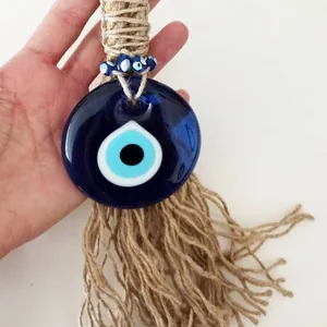 Macro detail of Turkish Evil Eye glass pendant with rustic jute rope and blue bead accents