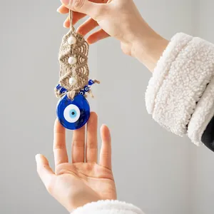 Detail of handmade evil eye glass charm with bohemian woven rope and white beads