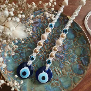 Bohemian woven evil eye wall hanging decor with blue glass beads and gold accents