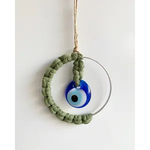Handmade green macrame evil eye wall hanging with blue glass charm and metal ring