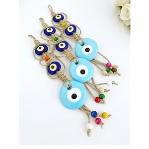 Dettaglio di decorazioni murali fatte a mano Evil Eye con corda di iuta e perline colorate