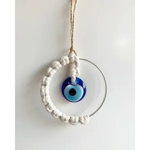 Detail of handmade woven Turkish evil eye wall hanging with white macrame texture
