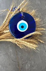 Detailed close-up of blue glass Evil Eye wall hanging charm with decorative jute rope