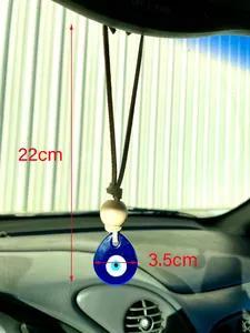 Close-up of blue glass Evil Eye pendant with wood beads hanging in a car interior