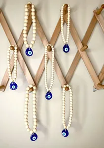 Detail of bohemian wood bead hanger with blue evil eye charm for car and wall decor