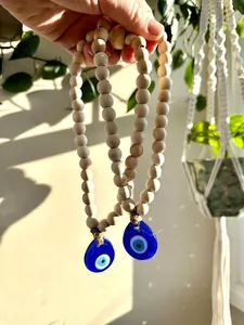Detail of Nordic wooden bead strands with blue glass evil eye pendants in sunlight