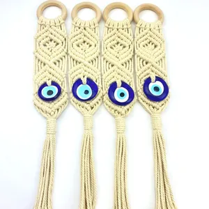 Detailed macro view of four handmade macrame evil eye wall hangings with cotton tassels