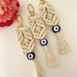 Detailed macro view of bohemian hand-woven cotton macrame evil eye keychains with tassels