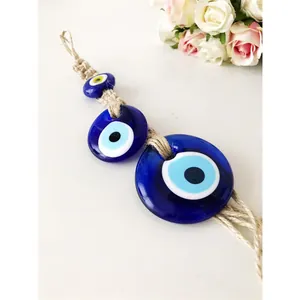 Dettaglio del ciondolo Evil Eye in vetro blu turco con corda di iuta per pareti