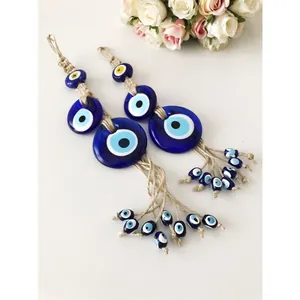 Dettaglio dell'occhio turco in vetro blu con corda di iuta e nappine per decorazione