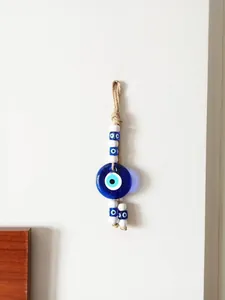 Dettaglio della decorazione da parete Evil Eye in vetro blu con corda di canapa naturale