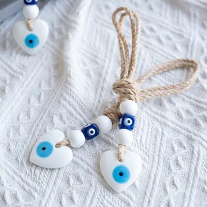 Detail of heart-shaped evil eye pendant with blue ceramic beads and natural jute rope