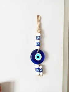 Dettaglio dell'amuleto malocchio in vetro fatto a mano con perle blu e corda di juta