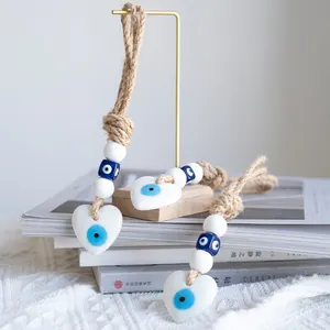 Detail of blue evil eye wall hanging set with heart pendant and rustic woven rope