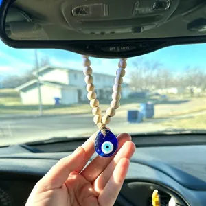 Nordic wooden beads evil eye car hanging charm displayed on a rearview mirror
