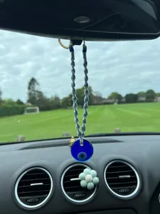 Handmade woven cotton rope Evil Eye car pendant hanging from a rearview mirror