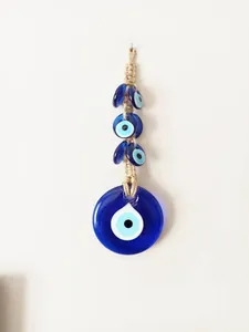 Detail of handmade evil eye wall hanging with woven twine and blue glass beads