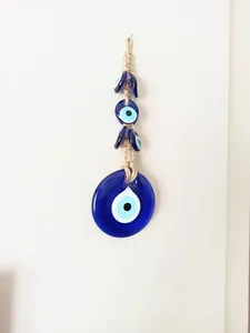 Macro detail of Turkish Evil Eye glass charm with handcrafted beige hemp rope braiding