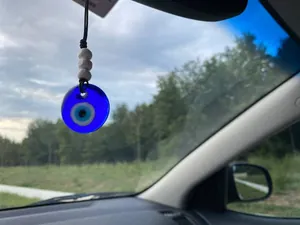 Detailed shot of Evil Eye car pendant with blue glass nazar and white wooden beads
