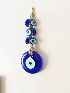Detail of handcrafted glass Evil Eye wall hanging with natural jute rope textures