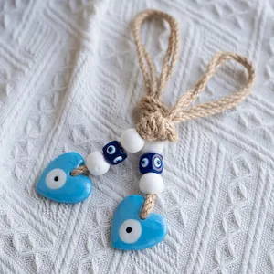 Macro detail of heart-shaped evil eye pendant with rustic jute rope and decorative beads
